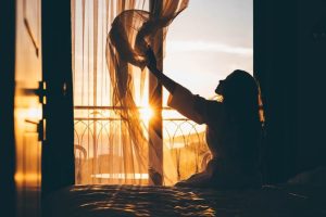 Woman observing her morning habits of watching the sunrise.